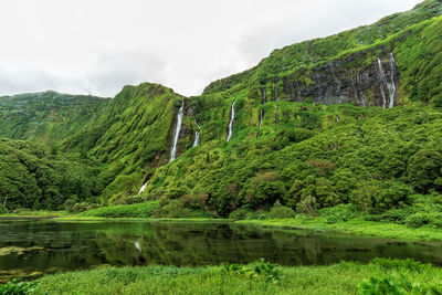 Scenic view of lake by mountain against sky