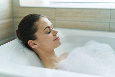 Close-up of woman relaxing in bathtub