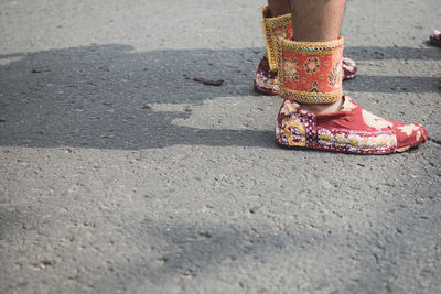 Low section of woman standing on road