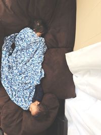 Low section of boy sitting on bed