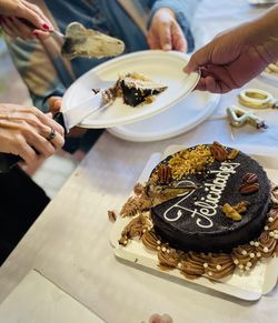 Cropped hand of man preparing food on table. birthday cake