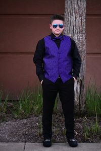 Man wearing sunglasses standing against wall
