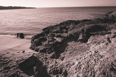 Scenic view of rocks on beach against sky