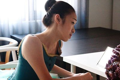Young woman sitting on table at home