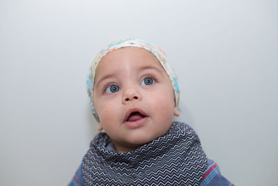 Close-up of cute baby boy against white background