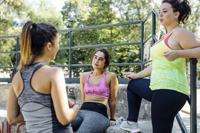 Female friends resting and taking after training in park