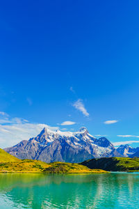 Scenic view of snowcapped mountains against blue sky