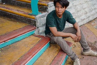 Portrait of man sitting on staircase