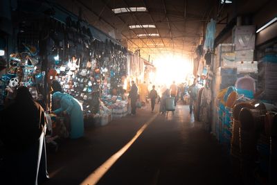 People on illuminated street market in city at night