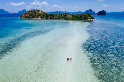 Drone view of couple at beach on sunny day