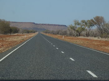 Road passing through landscape against clear sky