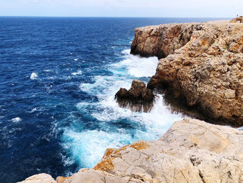 Scenic view of rocks in sea against sky