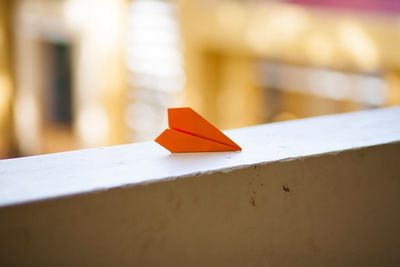 Close-up of paper airplane on retaining wall