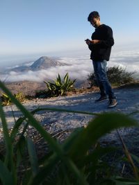 Full length of man standing on mountain against sky