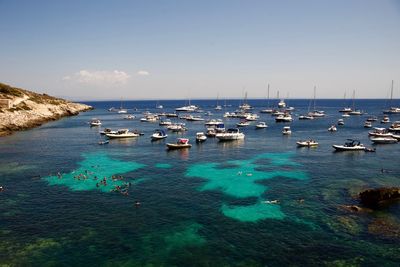 Sailboats moored on sea against sky