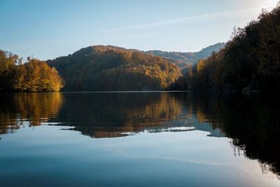 Scenic view of lake by trees against sky