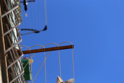 Low angle view of barbed wire against clear blue sky