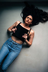 Portrait of young woman sitting on wall