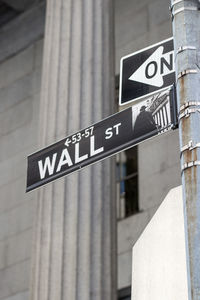 Low angle view of road sign against built structure