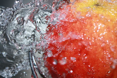Close-up of water falling on apple