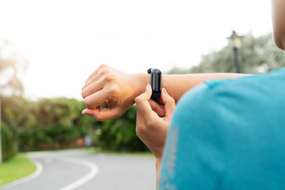 Fitness woman runner setting up smart watch before running. outd