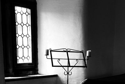 Candlestick holder by window against wall