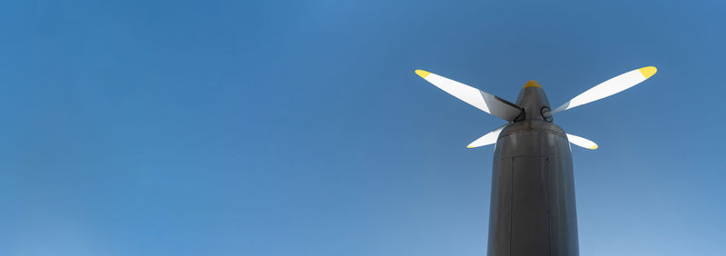 Low angle view of windmill against clear blue sky