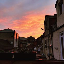 Street amidst buildings against sky during sunset