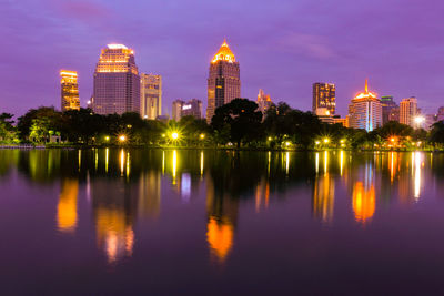 Reflection of buildings in lake at night