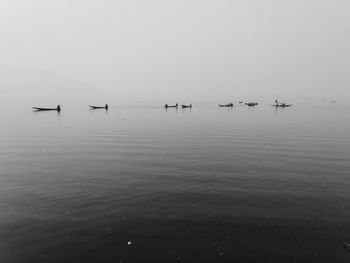 Sailboats in sea against sky