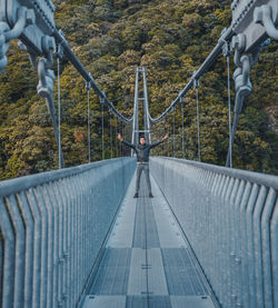 View of bridge with a man standing with hands raised