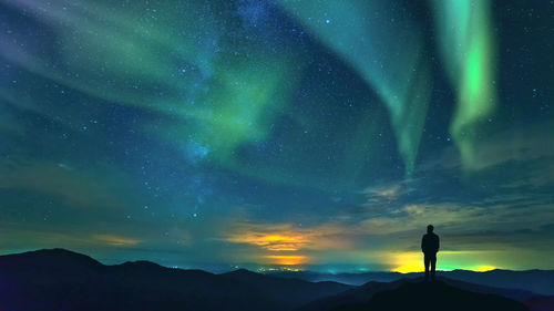 Rear view of man standing against sky during sunset