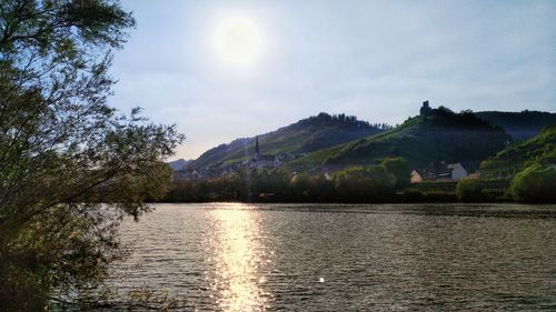 Scenic view of lake by mountains against sky