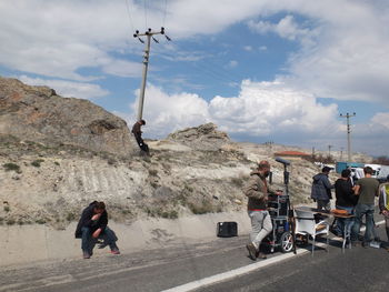 Crew on road against mountains in sunny day