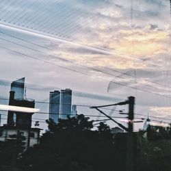 Modern cityscape against sky during sunset