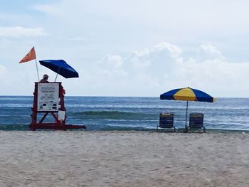 Lifeguard hut on beach against sky