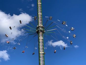 Low angle view of chain swing ride against sky