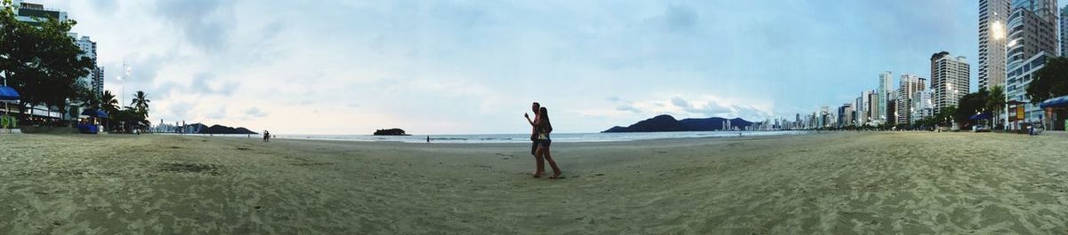 Scenic view of beach against cloudy sky
