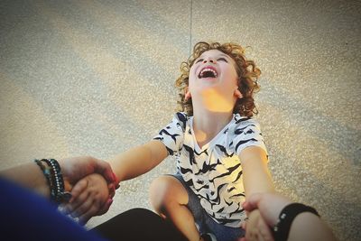 Low section of woman holding girl sitting outdoors