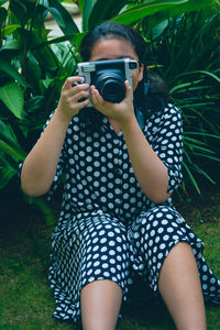 Midsection of woman holding camera