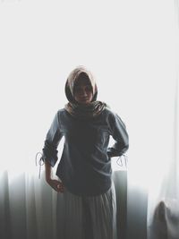 Portrait of young woman standing against sky