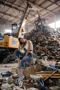 Portrait of young woman against garbage heap