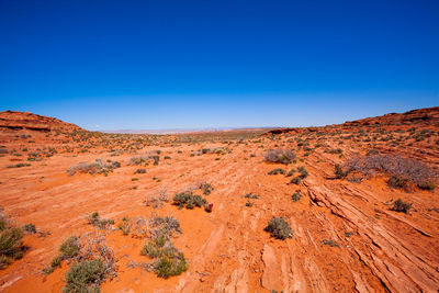 Scenic view of desert against clear blue sky