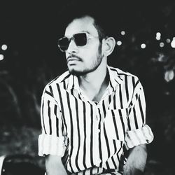 Portrait of young man wearing sunglasses standing outdoors