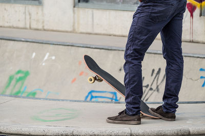 Low section of man skateboarding on street