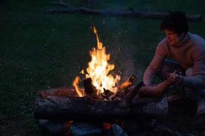 Man by campfire on field