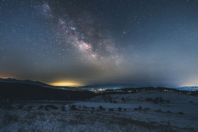 Scenic view of snowcapped mountains against sky at night