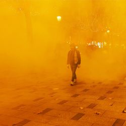 Rear view of man walking on street at night
