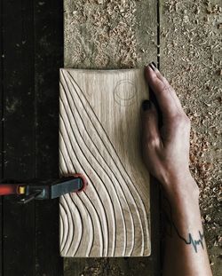 High angle view of person hand on wood