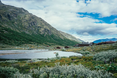 Scenic view of lake by mountains against sky